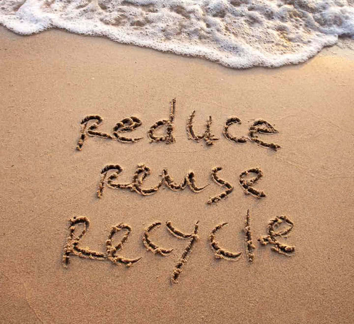 "reduce reuse recycle" written on the beach